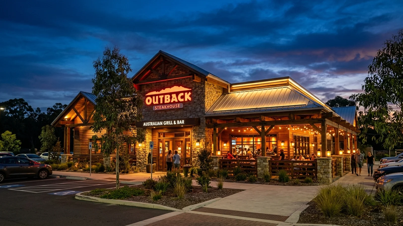 Outback Steakhouse timber exterior with warm ambient evening lighting and red glowing signage